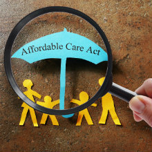 A paper cutout family under an Affordable Care Act umbrella