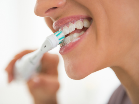Woman using a power toothbrush